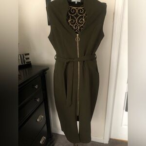 Green sleeveless dress with gold fixtures. A zipper down the middle of the dress